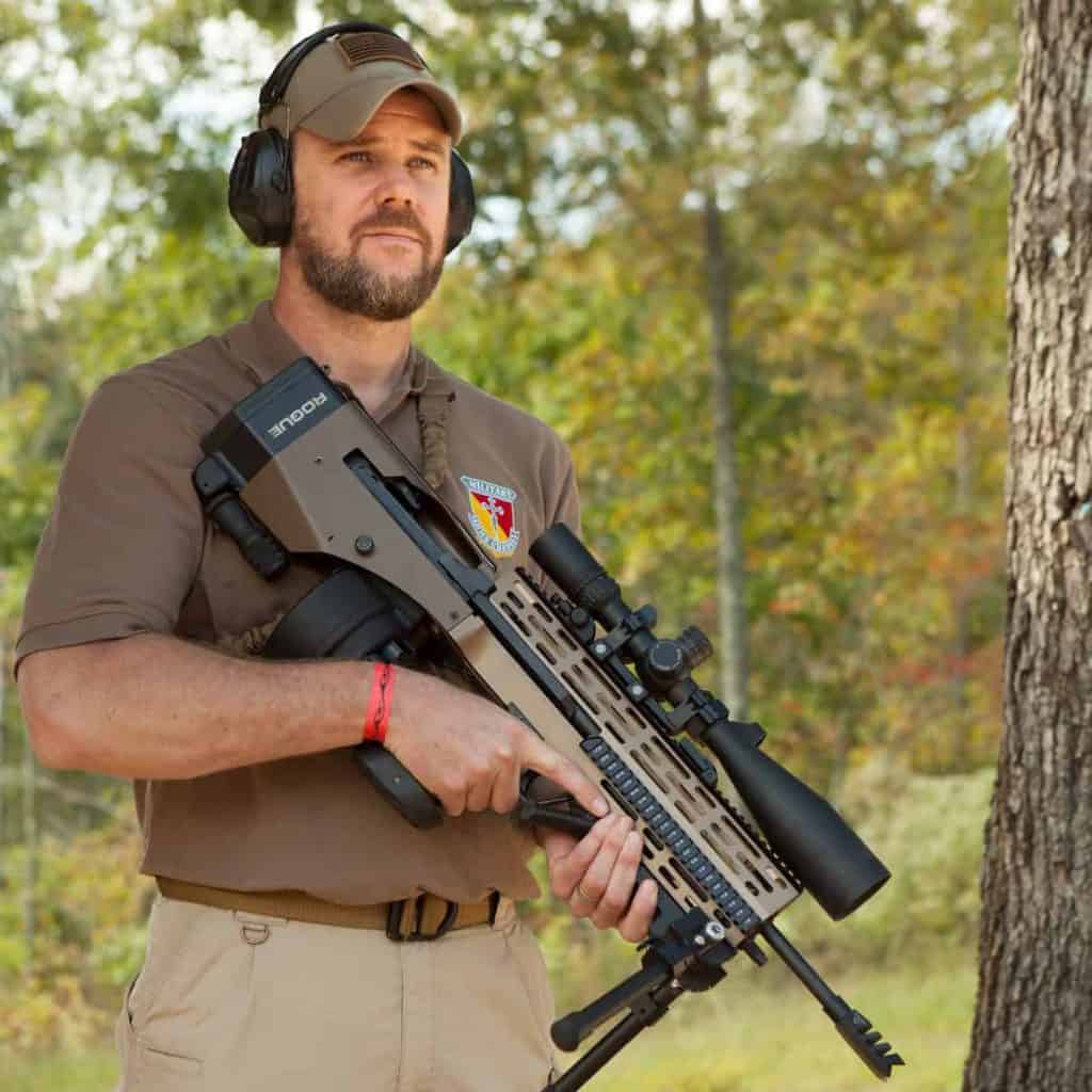 Tim Harmsen, Face Off host, holding a scoped precision rifle at an outdoor range
